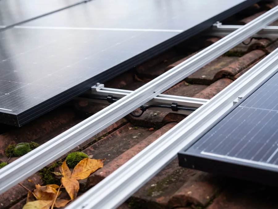 Solarmodule auf Aluminium-Montageschienen über einem roten Ziegeldach